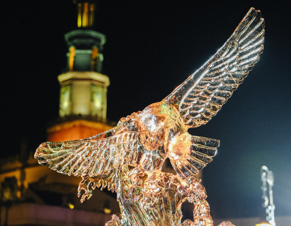 Two sculptures with Poznań's Old Market Square in the background