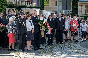 Delegacje z kwiatami, w tle tramwaj.