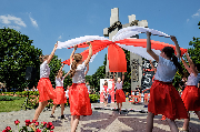 Dziewczymnki w biało-czerwonych barwach tańczą z szarfami.
