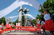 Dziewczynki falują biało-czerwonymi szarfami.