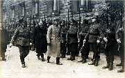 Józef Piłsudski przechodzi przed frontem kompanii honorowej w towarzystwie cywili i wojskowego.