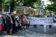 Trmawaje i składający kwiaty uczestnicy obchodów rocznicowych.